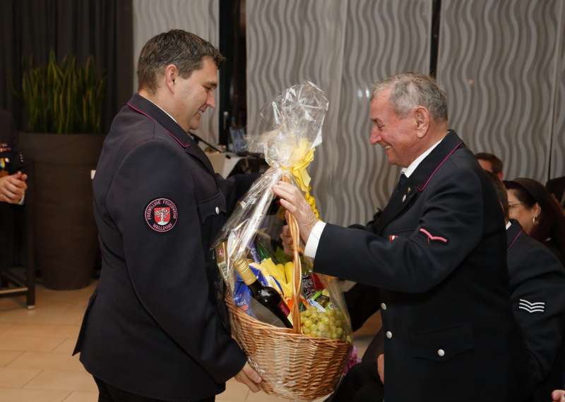 Karl Winnes (rechts) wird für 60 Jahre bei der Feuerwehr geehrt und bekommt einen Geschenkkorb überreicht (Foto: Jan A. Pfeifer)