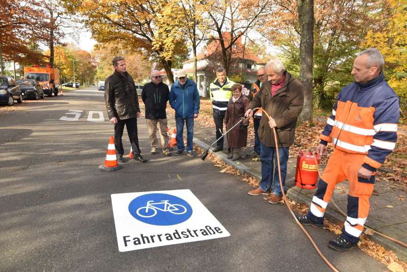 Fahrradstraße Knielinger Allee: Bürgervereinsvorsitzender Peter Cernoch legt im Beisein von Bürgern der Nordstadt selbst Hand an beim Aufbringen der Fahrradstraßenpiktogramme (Foto: Stadt Karlsruhe)