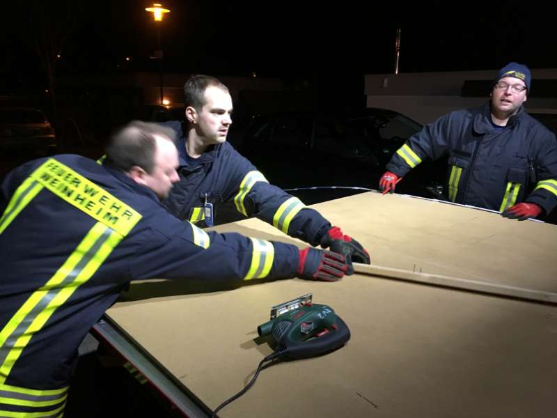 Die Feuerwehrangehörigen Marc Fath, Christopher Quintel und Dirk Baumann die eine Platte zuschneiden um eine Notverschalung in der Zinkgräfstraße durchzuführen. (Foto: Ralf Mittelbach)