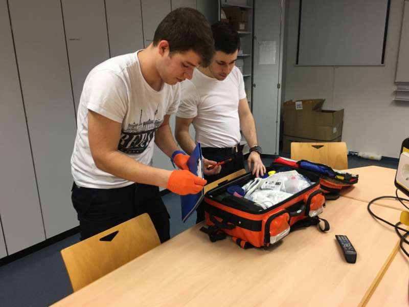 Die Feuerwehrsanitäter (v.l.) Johannes Ernst und Christian Paradiso, die nach einem Einsatz den Einsatzrucksack kontrollieren und wieder mit neuem Material bestücken. (Foto: Ralf Mittelbach)