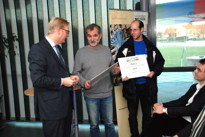 Markus Frank übergibt Scheck an Aron Seng und Christian Walter von der SG Bornheim Grün-Weiss (Foto: Stadt Frankfurt)