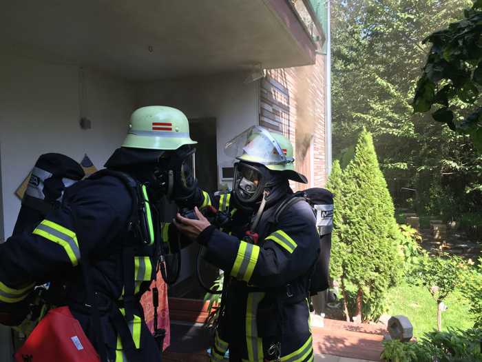 Angriffstrupp macht sich fertig. Hintergrund Rauch aus Küchenfenster