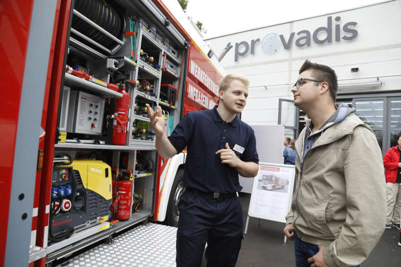 Der angehende Werkfeuerwehrmann Patrick Lorz (l.) erklärt Besucher Yannik Weis das Universallöschfahrzeug der Werkfeuerwehr des Industrieparks Höchst. (Foto: 2017 Provadis Partner für Bildung und Beratung GmbH)