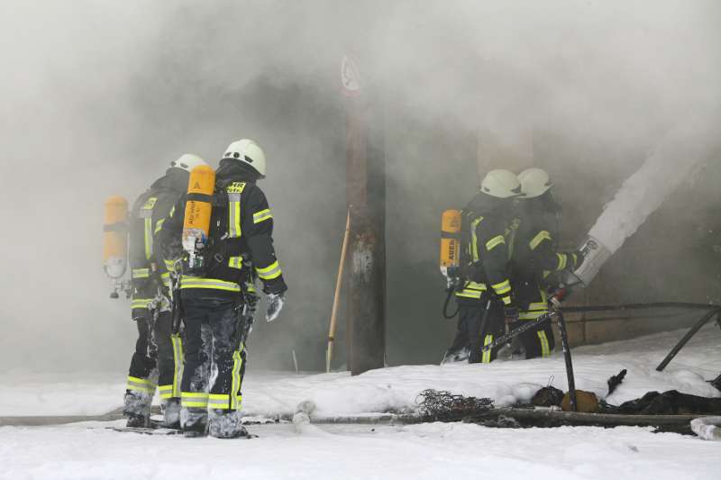 Feuerwehrleute unter schwerem Atemschutz beim Löschen mit Schaum (Foto: A. Luipold)