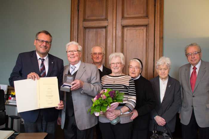 Oberbürgermeister Thomas Feser (li.) gratuliert Friedel Roos zum Stadtsiegel. Weitere Gratulanten (v. re.): Oberbürgermeister a. D. Erich Naujack, Elisabeth Naujack, Schwester Simone Rollmann, Ehefrau Ingrid Roos und Pater Jürgen Jagelki. Foto: Stadt Bingen