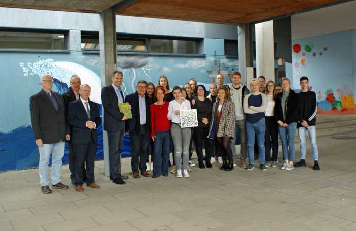 Stadtbürgermeister Ludwig Lintz, der Beigeordnete der Verbandsgemeinde Edenkoben Eberhard Frankmann, Schulleiter Ulrich Erfort, Landrat Dietmar Seefeldt, Kreisbeigeordneter Bernd E. Lauerbach und Susanne Wadle (v.l.n.r.) sowie der stellvertretende Schulleiter Michael Schacht (8.v.r.) mit den Schülerinnen und Schülern des Projekts „Wandgestaltung