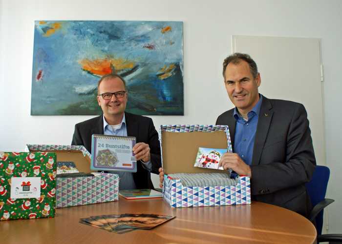 Der Erste Kreisbeigeordnete Marcus Ehrgott und Landrat Dietmar Seefeldt haben selbst Päckchen für den Weihnachtspäckchenkonvoi zusammengestellt.