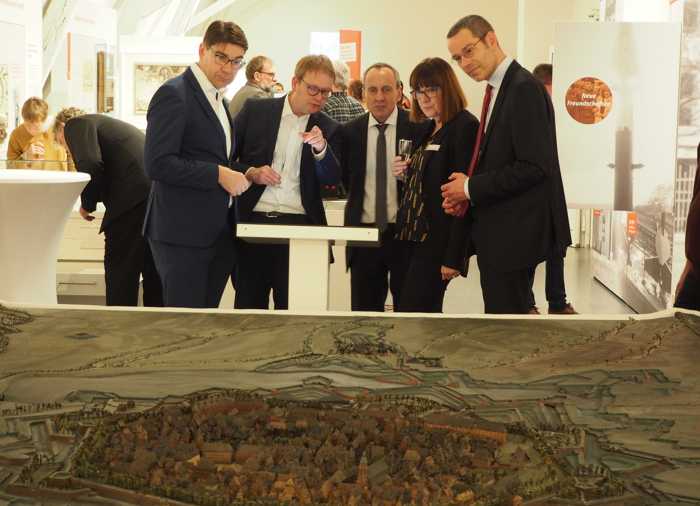 Gemeinsam bei der Eröffnung des neuen Museums für Stadtgeschichte Landau in der Pfalz am großen Festungsmodell: Oberbürgermeister Thomas Hirsch, Bundesstaatssekretär Dr. Thomas Gebhart, der rheinland-pfälzischen Kulturminister Prof. Dr. Konrad Wolf, die Leiterin des Archivs und Museums, Christine Kohl-Langer, und Bürgermeister Dr. Maximilian Ingenthron (v.l.n.r.). (Quelle: Stadt Landau in der Pfalz).