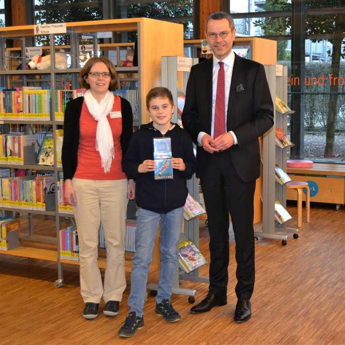 Der zehnjährige Julian Siener ist Hauptgewinner des landesweiten Quizrätsels im Rahmen der Bibliothekstage Rheinland-Pfalz 2018 und darf sich über den Gewinn einer Action-Cam freuen. Bürgermeister Dr. Maximilian Ingenthron und die Leiterin der Landauer Stadtbibliothek, Amelie Löhlein, gratulieren. (Quelle: Stadt Landau in der Pfalz)