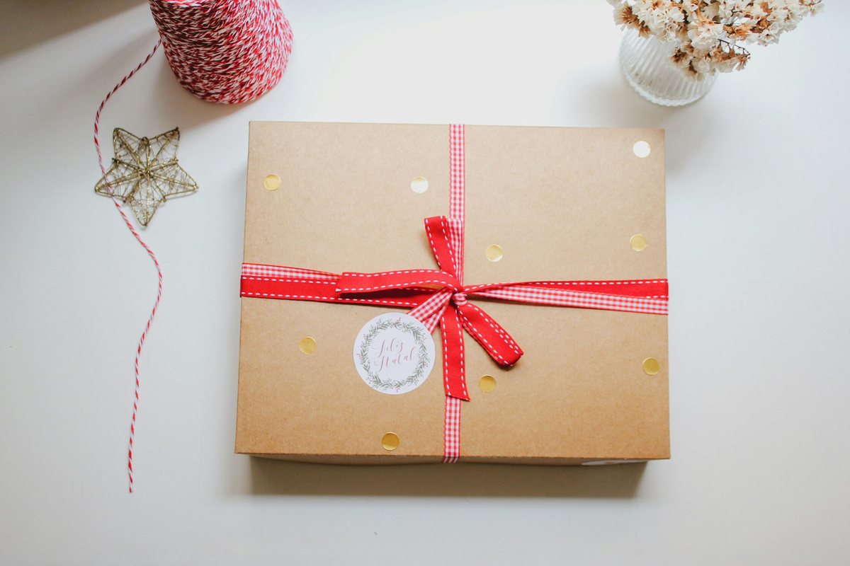 In Packpapier und rotes Band eingewickeltes Geschenk