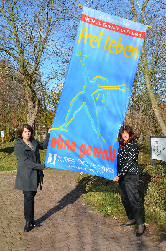 Frauenbeauftrage Barbara Dees und Landrätin Theresia Riedmaier hissen die Fahne „Frei leben – ohne Gewalt“ am Kreishaus der Südlichen Weinstraße.