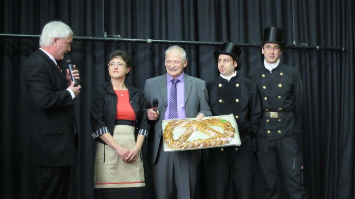 Bäckermeister Lothar Bisson (3. v. l.) überreicht Ortsvorsteher Christoph Heller (l.) eine große "Neujahrsglücksbrezel"