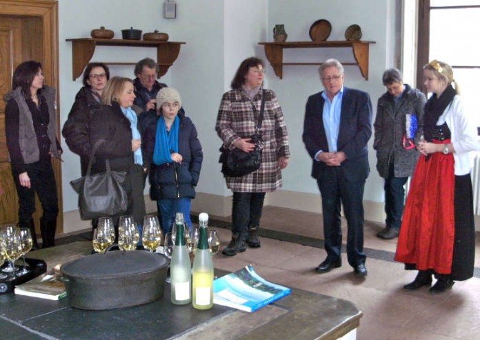 Grußworte und Secco in der Schlossküche: Gästeführerin Martina Roth (links), Stadtbürgermeister Werner Kastner (zweiter von rechts), Weinprinzessin Lena Edel (rechts) mit Zuhörern.