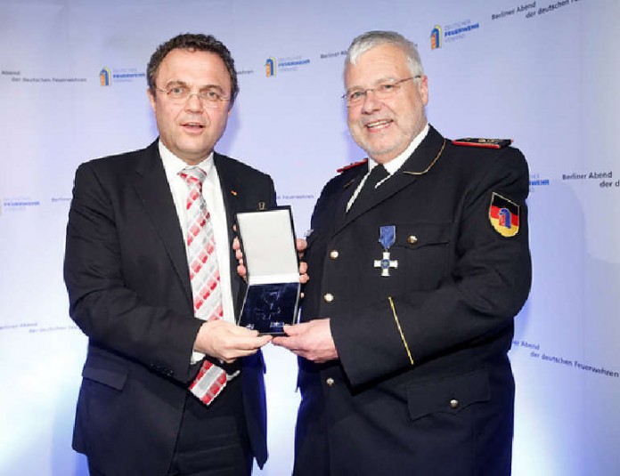 Dr. Hans-Peter Friedrich überreicht DFV-Präsident Hans-Peter Kröger die Ehrennadel des THW.