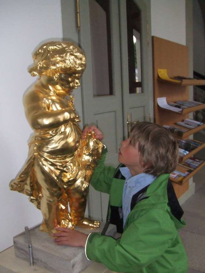 Kind beim Erkunden einer Statue