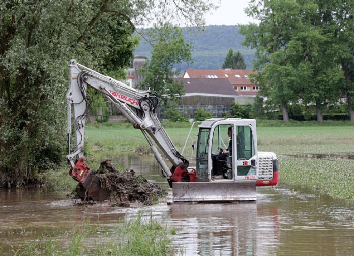 Mit einem Bagger öffnet das Tiefbauamt einen Damm, damit das Wasser von den Salmwiesen besser abfließen kann.