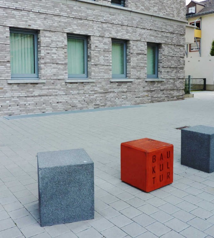 Rote Sitzwürfel, die als „Sehstation“ vor architektonisch wertvollen Gebäuden Mannheims aufgestellt werden.