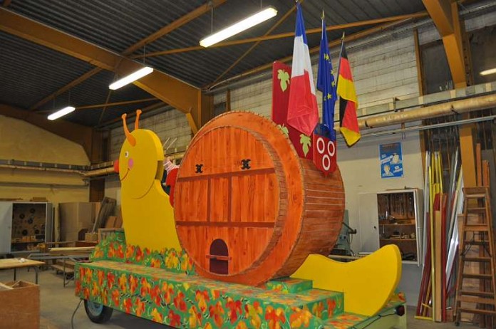 Zum Motiv des Festwagens: Die Schnecke steht für die Region Burgund (seit 1957 Partnerregion von Rheinland-Pfalz). Ihr Kopf bewegt sich, das Schneckenhaus hat die Form eines Fasses.
