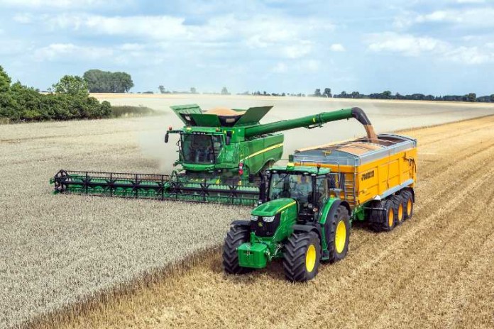 Traktor und Mähdrescher bei der Ernte Seite an Seite Zwei Bilder der neuen kompakten Traktorenbaureihe 6MC und 6RC aus dem John Deere Werk Mannheim