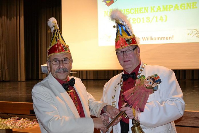 Ehrenpräsident Ulrich Seelmann überreicht die Narreninsignien an Sitzungspräsident Markus Kern (rechts).