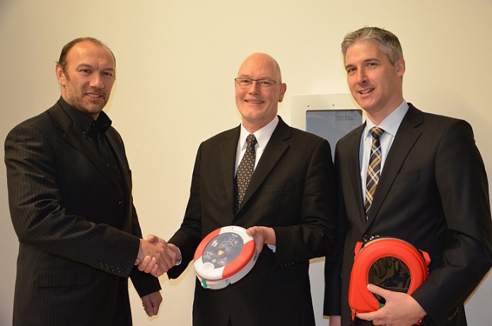 Uwe Reichel und Dietrich Nagel, beide von der BBBank Mannheim, übergeben Michael Schnellbach, Fachbereichsleiter Bürgerservices, fünf neue Defibrillatoren für die Bürgerservices
