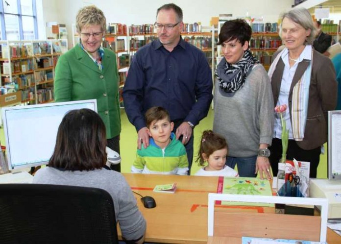Familie Hildenbrand löst den Gutschein für die Jahresgebühr der Stadtbibliothek ein