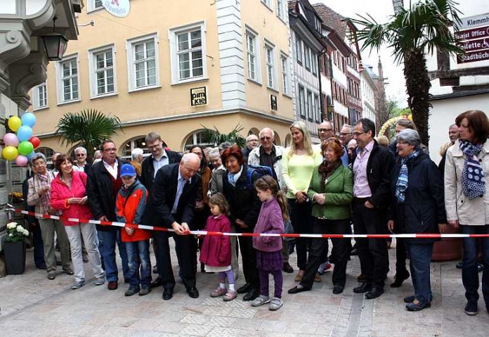 Oberbürgermeister Hans Georg Löffler (Mitte) durchschneidet gemeinsam mit vielen Bürgerinnen und Bürgern das Band. Damit ist der zweite Teil der sanierten Hauptstraße freigegeben