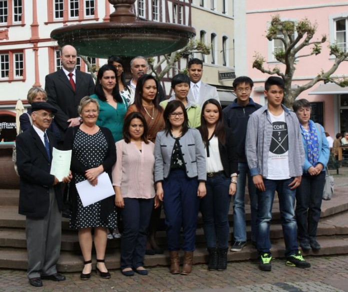 Der zuständige Dezernent Georg Krist (li. oben) mit den neuen Mitbürgerinnen und Mitbürgern sowie Verwandten und Freunden.