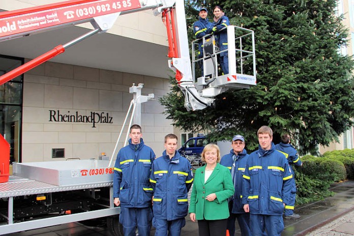 Maria Böhmer (Mitte) mit Helfern des THW Frankenthals. Lukas Kalnik (Zweiter von links), stellvertretender THW-Ortsbeauftragter Frankenthal, wird den Weihnachtsbaum offiziell übergeben.