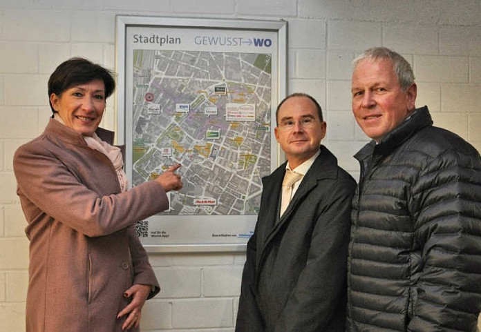 Citymanagerin Heike Noeller, Alexander Möller für die Parkhausbetriebs GmbH und Stadtmanager Kai Hornuf präsentieren den neuen Stadtplan im Eingang des Parkhauses am Theater.