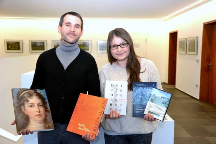Daniel Binder Volontär bei den Städtischen Museen, und Elif Tek, Auszubildende im Stadtarchiv, präsentieren Geschenkideen ihrer Kultureinrichtungen.