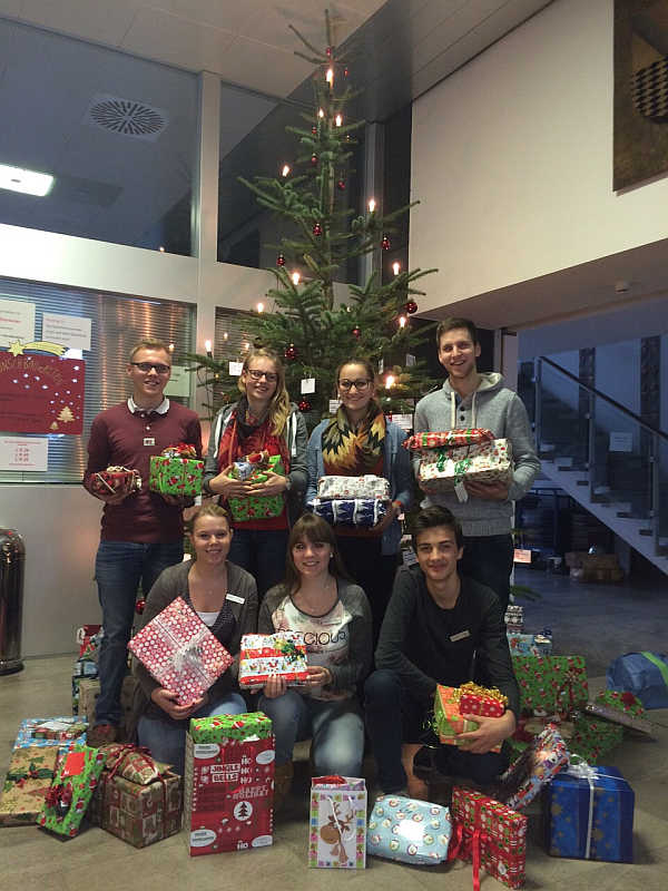 Mit großer Freude über das Projekt präsentieren die Jugend- und Auszubildendenvertreter gemeinsam mit Auszubildenden einige der Geschenke vor dem Weihnachtsbaum des Landratsamtes.
