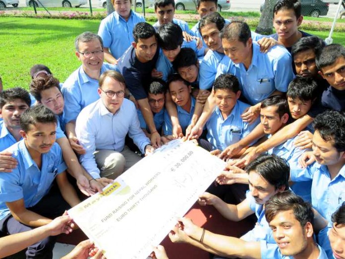 Symbolische Spendenübergabe: Christoph Fark, Leiter des Geschäftsbereichs Advanced Optics, und Werksleiter Harry Choi (Mitte) in Penang mit den betroffenen Kollegen aus Nepal