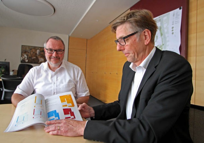 Oberbürgermeister Ralf Claus erhält die gebundene Ausgabe des Corporate Design Handbuchs vom Grafikbüro Incom, Thilo Hoffmann