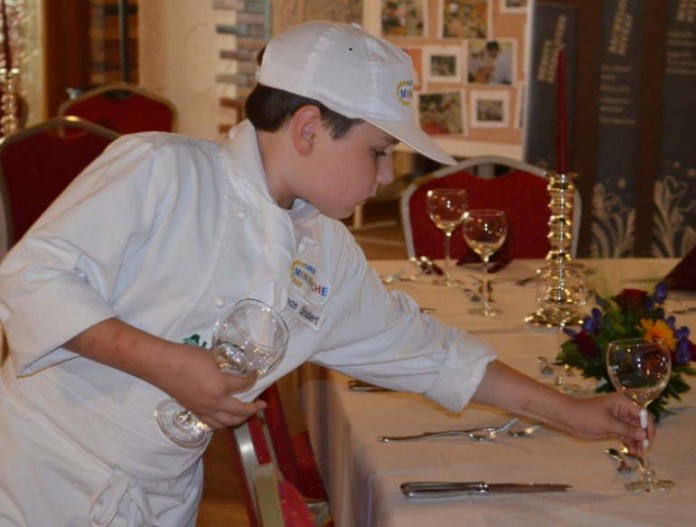 Mini-Koch beim Tisch eindecken