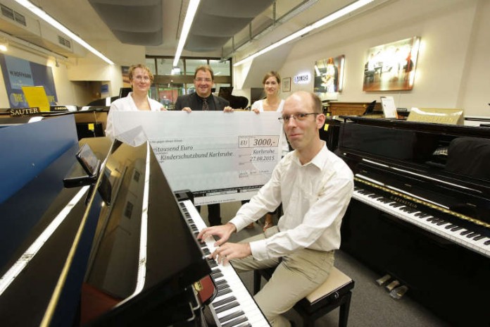 Den Erlös in Höhe von 3.000 EUR haben Bürgermeisterin Gabriele Luczak-Schwarz, Citymanager Sascha M. Binoth und „Spiel mich!“-Initiator Peter Schlaile im Musikhaus Schlaile an den Kinderschutzbund Karlsruhe übergeben