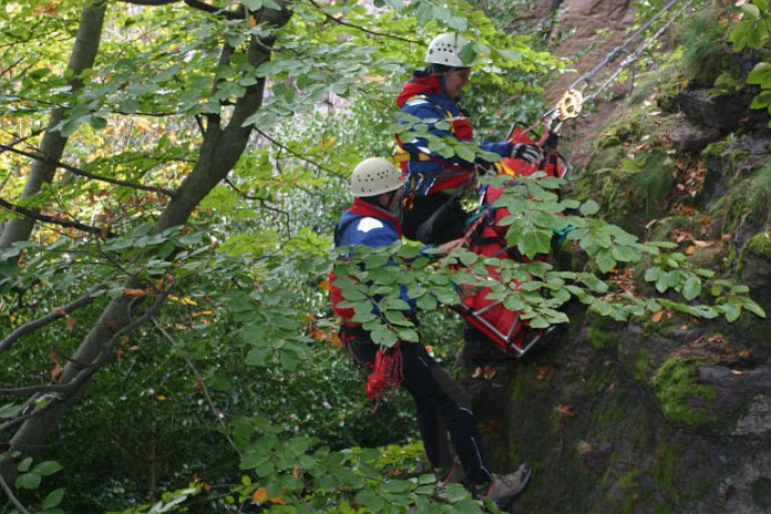Bergretter an Steilwand im Wald