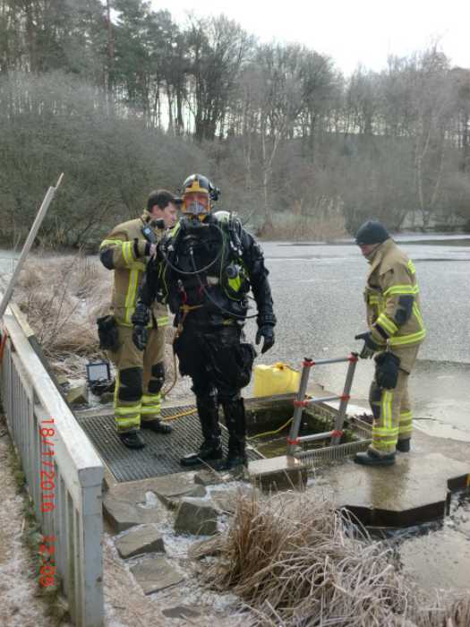 In Tauchausrüstung half die Feuerwehr bei den Reinigungsarbeiten am Wasserzulauf des Vogelwoogs