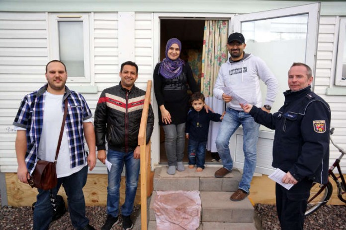 v.l.: Manuel Mühl und Mohamed Abdel-Galil (beide Stadtverwaltung Neustadt), eine Flüchtlingsfamilie und Polizeioberkommissar Bernd Schmidt