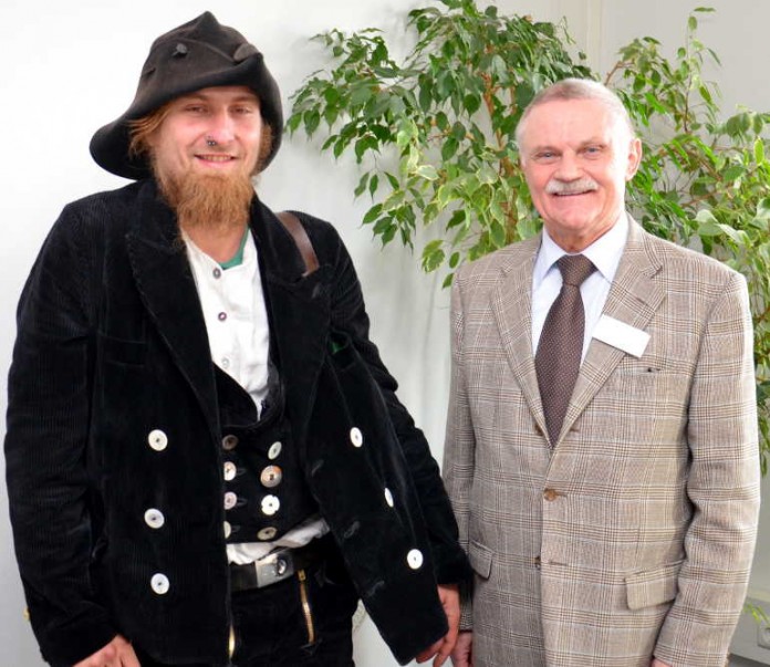 Der Erste Kreisbeigeordnete Adam J. Schmitt berüßt den fremd- und freireisenden Zimmerer „Eddi“ in der Kreisverwaltung zum Vorsprechen