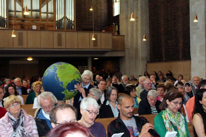 Eine von der Evangelischen Jugend gestaltete Weltkugel wandert durch die Bankreihen