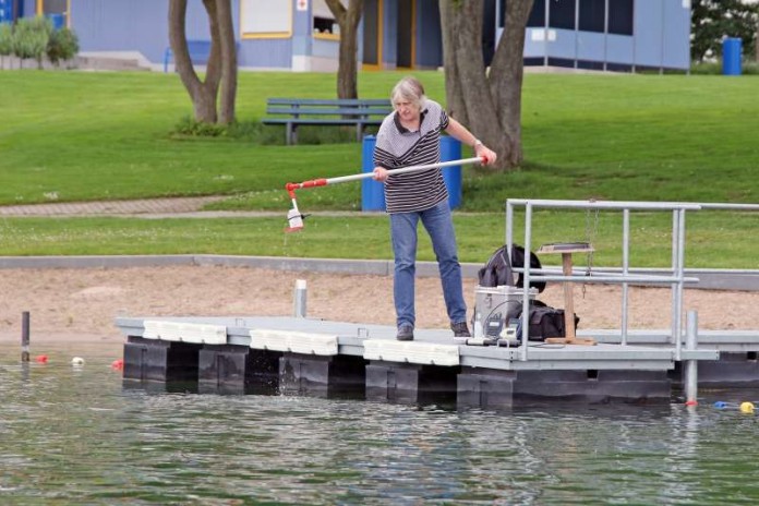 Der für die Überprüfung der Wasserqualität zuständige Mitarbeiter im Gesundheitsamt, Albert Karras, entnimmt auf diesem Bild am Badesee in St. Leon-Rot eine Wasserprobe. (Foto: Landratsamt Rhein-Neckar-Kreis)