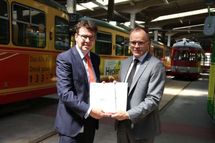 Übergabe der beiden Energieauditberichte von Michael Homann, Vorsitzender der Geschäftsführung der Stadtwerke Karlsruhe (r.) an Dr. Alexander Pischon, Vorsitzender der Geschäftsführung VBK und AVG (Foto: Verkehrsbetriebe Karlsruhe GmbH)