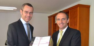 Bürgermeister Dr. Maximilian Ingenthron (links) und Jürgen Büchler, Vorstandsmitglied der VR Bank Südpfalz bei der Übergabe der Baugenehmigung (Foto: Stadt Landau in der Pfalz)