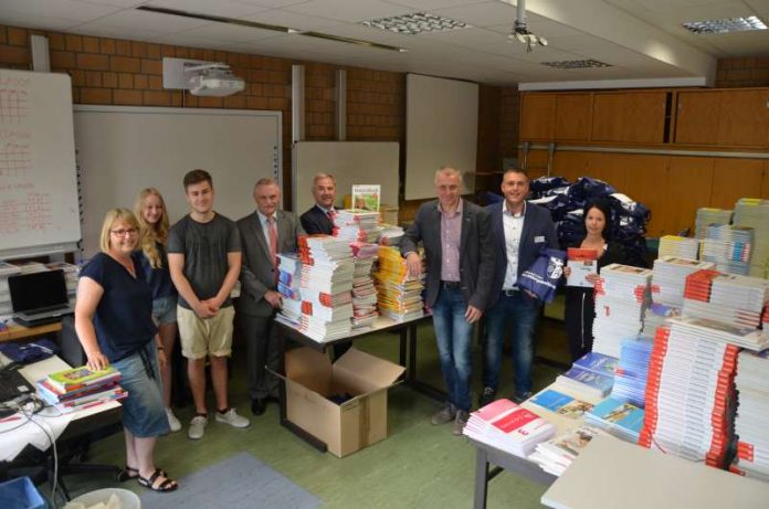 Landrat Claus Schick (4.v.r.) und der Erste Kreisbeigeordnete Adam J. Schmitt (4.v.l.) machen sich ein Bild von der Vorbereitung der Schulbuchausleihe am Gymnasium Nackenheim. (Foto: Kreisverwaltung Mainz-Bingen)