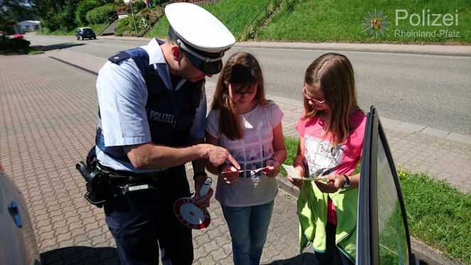 Polizeikommissar Alexander Vogt mit den Schülerinnen Sarah-Lee Vogt und Kira Uhl