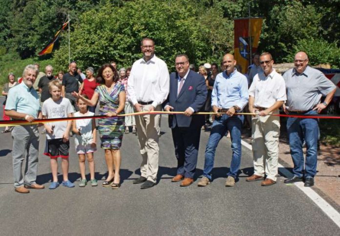 Feierliche Verkehrsfreigabe der K12: Staatssekretär Andy Becht (4.v.r.) durchtrennt gemeinsam mit Landrätin Theresia Riedmaier (4.v.l.) sowie Hermann Bohrer, den beiden Kindern Leon und Melanie aus Blankenborn, Alexander Schweitzer, Martin Wichmann (Beigeordneter Stadt Bad Bergzabern), Michael Nauth (Ortsvorsteher Blankenborn) und Kreisbeigeordnetem Helmut Geißer (v.l.n.r.) das Band. (Foto: Kreisverwaltung Südliche Weinstraße)