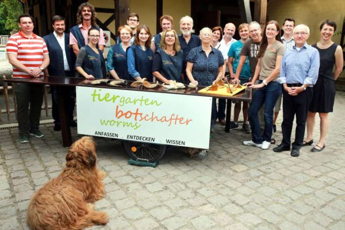 Die gute Laune steckt an: Die Tiergartenbotschafter mit ihrem neuen Infomobil. Michael Kauer, Zoologische Gesellschaft Frankfurt, Tiergartenleitung Wilfried Adelfinger und Marco Mitzinger, Revierleiterin Nina Au, Dennis Waltenberg vom Erlebnisgarten Worms, waren für das Ehrenamt für Worms Theo Cronewitz (1.VS), Agnes Denschlag (2.VS) und Günter Zutavern (Kassenführer) zugegen. (Foto: Uhrig)