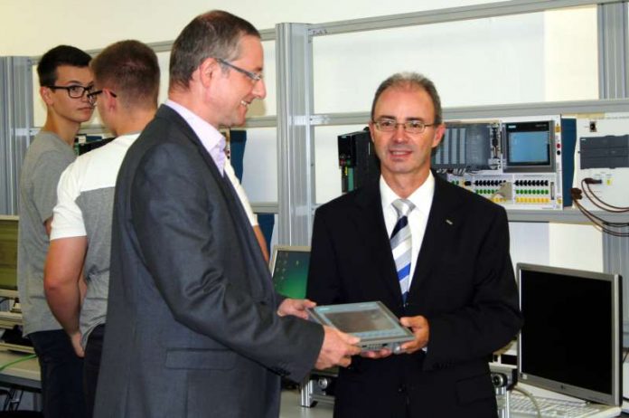 Übergabe der Sachspende von Achim Pecka (rechts) an Jens Leilich. Im Hintergrund: Nils Bürger (links) und Maximilian Huy (rechts), beide Schüler an der Karl-Hofmann-Schule. (Foto: Siemens AG)