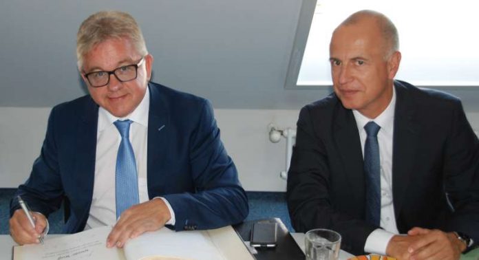 Minister Wolf trägt sich in das Gästebuch der JVA Bruchsal ein. Rechts neben dem Minister sitzt Martin Finckh, Leiter der Abteilung Justizvollzug des Ministeriums der Justiz und für Europa Baden-Württemberg. (Foto: Ministerium der Justiz und für Europa)